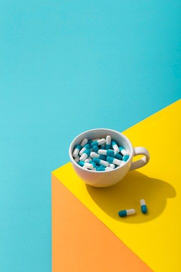 high-angle-of-mug-with-multiple-pills_23-2148530999