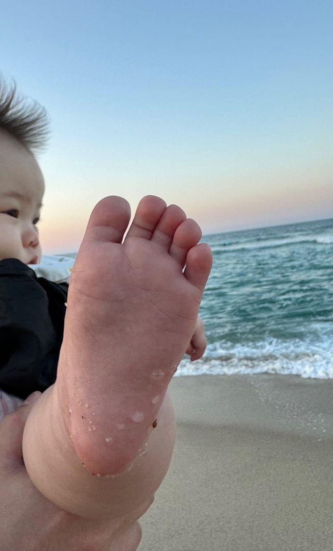 Baby's feet on the beach for the first time