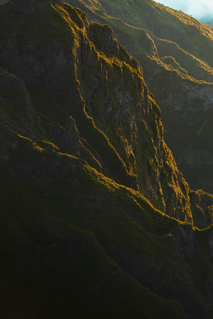 a view of the top of a mountain in the sun