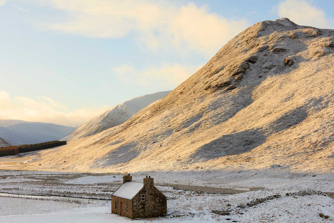 a remote snow covered cottage sits in the hills outside braemar