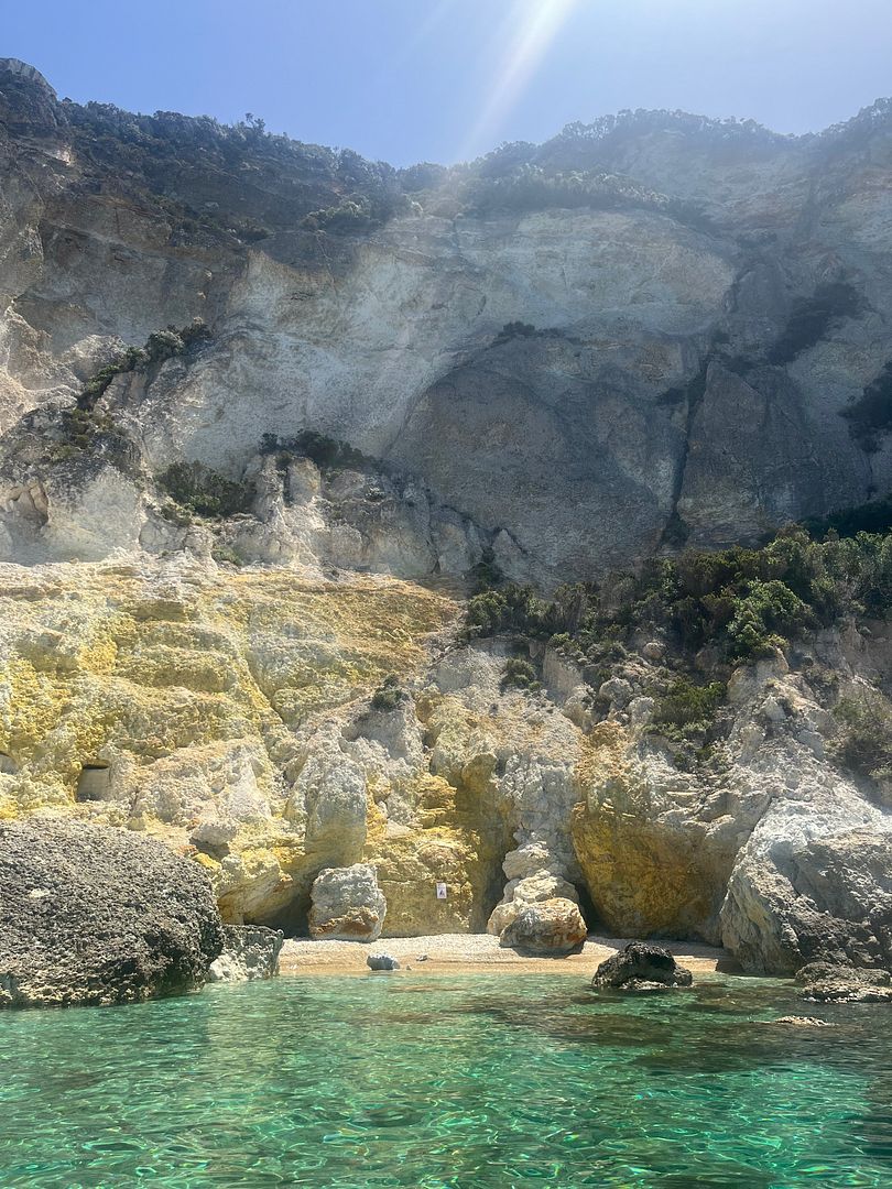 By dinghy; Yellow rocks; Crystal clear water.