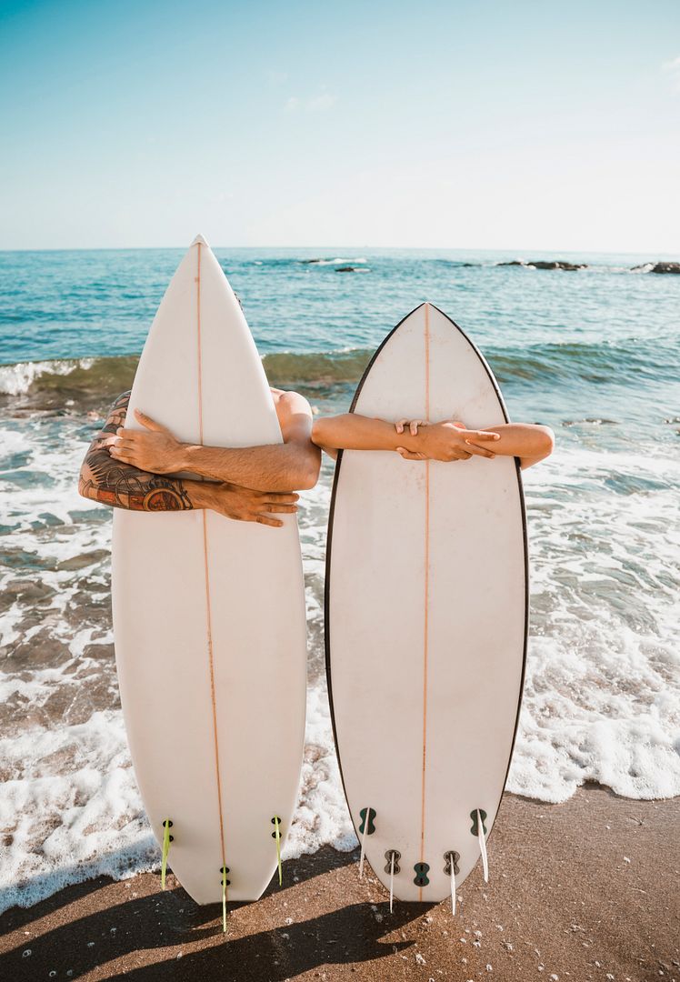 young-man-woman-with-surf-boards-coast-near-sea