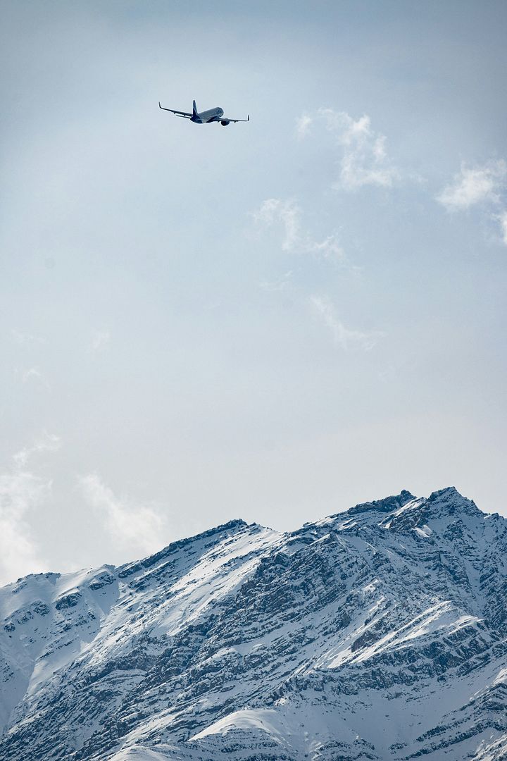 an airplane is flying over a snowy mountain