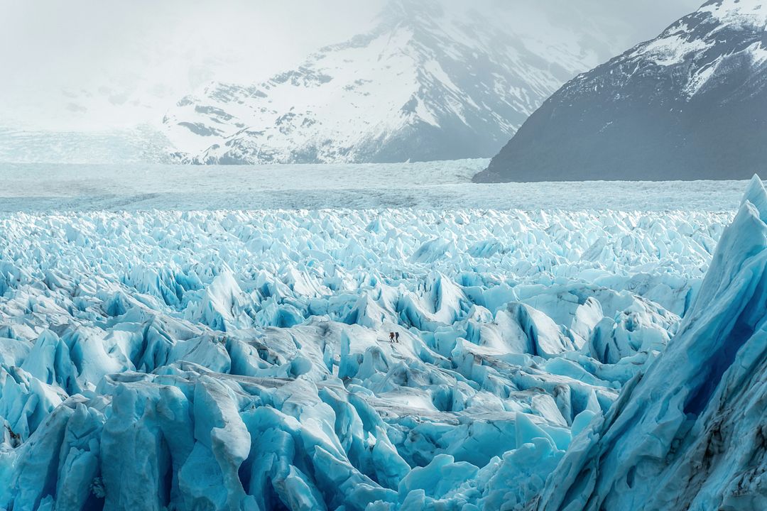 2 people hike on a glacier in Patagonia.