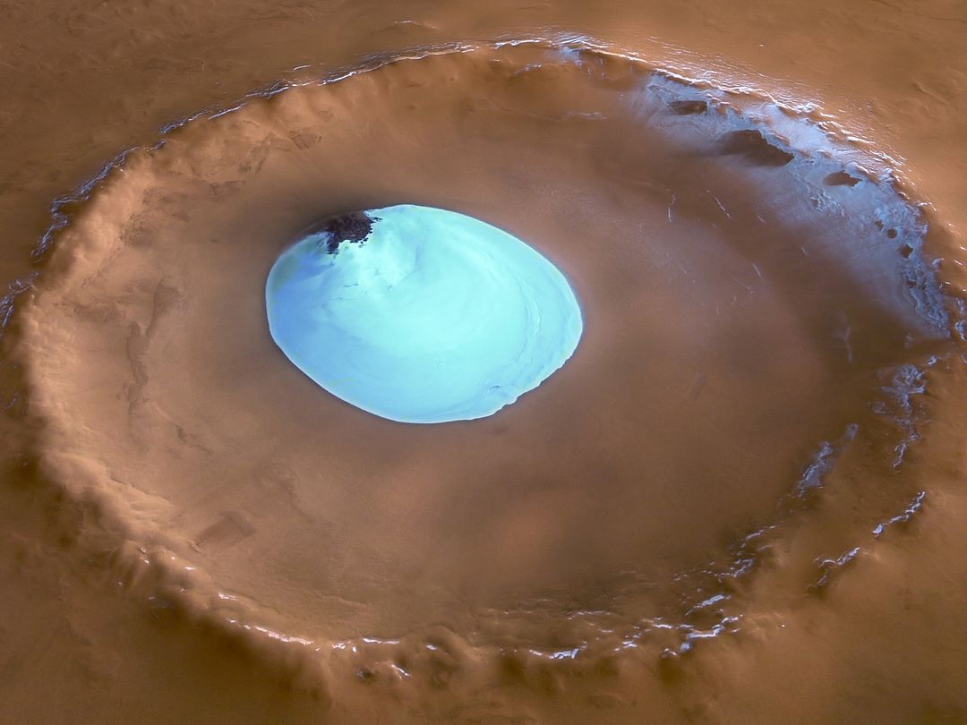 The image shows a lake on Mars with a blue surface on a brown background.  According to scientists, there were once rivers and lakes on Mars. To this day, there is enough water on the planet, but only in the form of ice.   In 2018, a subglacial lake on Mars was discovered, located at a depth of 1.5 km under the ice of the Southern Polar Cap, about 20 km wide. This became the first known permanent body of water on Mars.   However, repeated analysis of the Mars Express radar data and laboratory experiments have shown that the so-called "lakes" can be hydrated and cold deposits, including clay, minerals containing metals, and salty ice.   Eridania is considered to be another large lake on Mars. It alone contained more water than all the other lakes of the Red Planet combined. Scientists suggest that the heyday of Eridania occurred 3.7 billion years ago. At first it was one large body of water, which, as the water level decreased, crumbled into several isolated lakes, and then disappeared altogether.