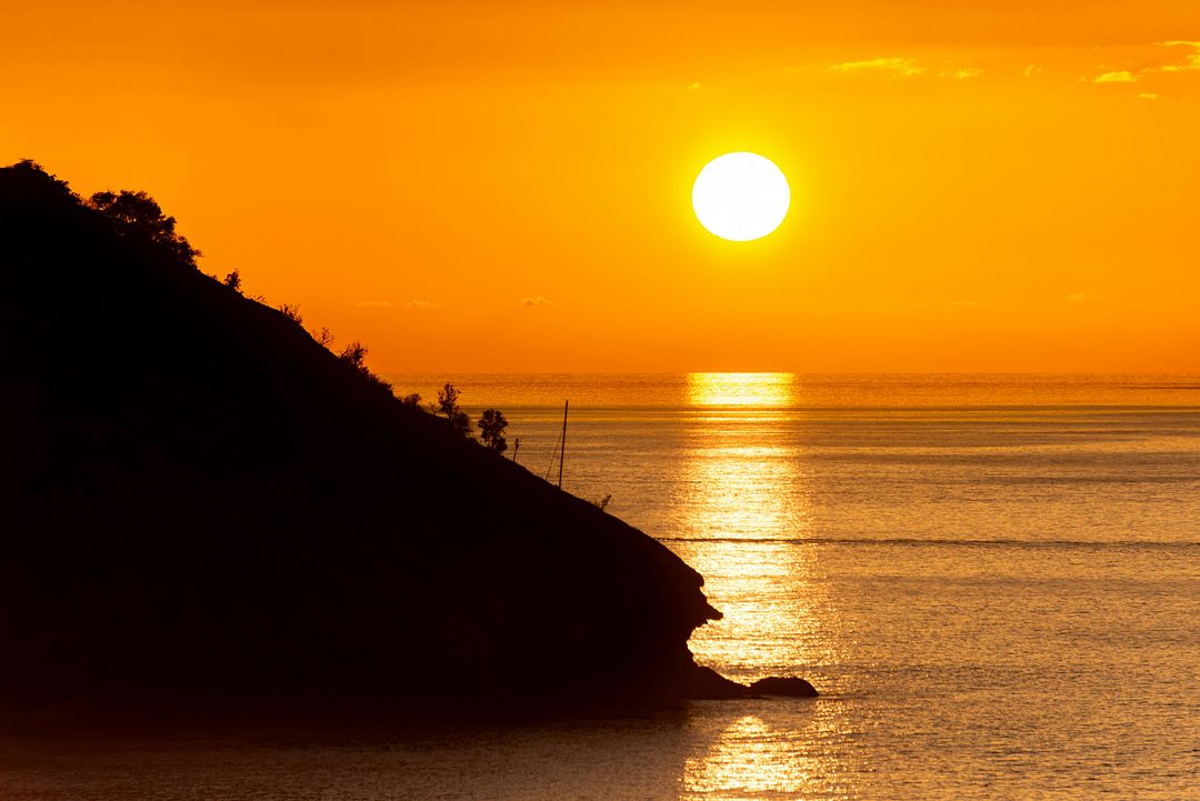 Sailing out of St. John Antigua at sunset on the Caribbean Sea.