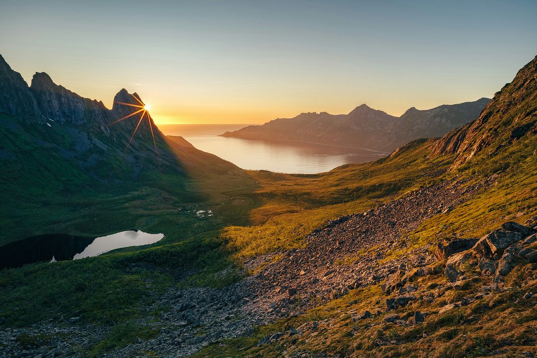 the sun is setting over a mountain range