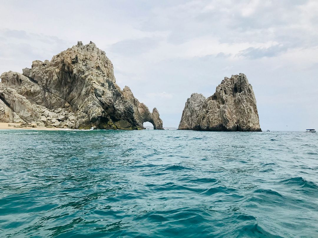 brown rock formation on body of water during daytime