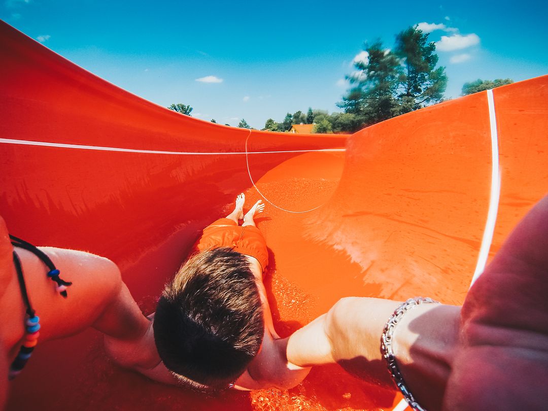 young man enjoying outdoor water slide