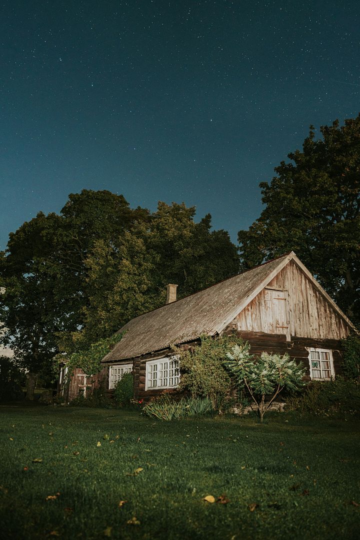 a house with a thatched roof in the middle of a field